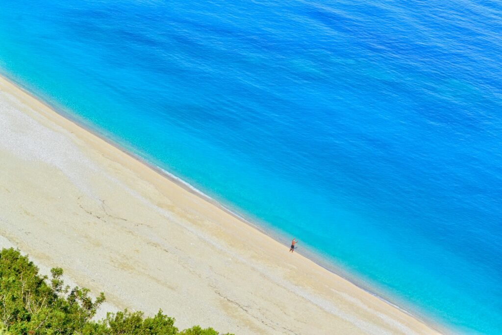 Stunning aerial view of Myrtos Beach's turquoise waters and sandy shore in Kefalonia, Greece.